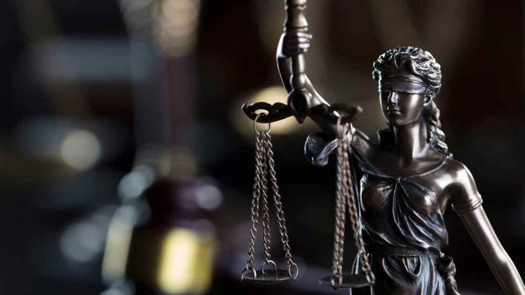  Close-up of Lady Justice holding balanced scales.