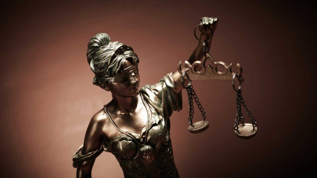 Bronze statue of Lady Justice holding balanced scales.